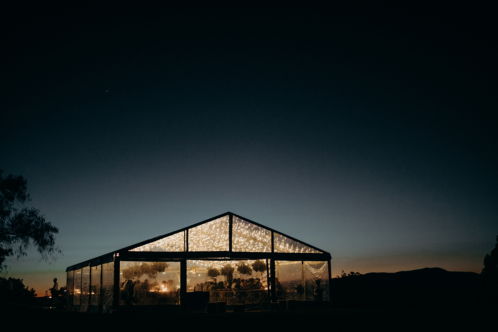 Wedding reception under a clear marquee with festoon lighting