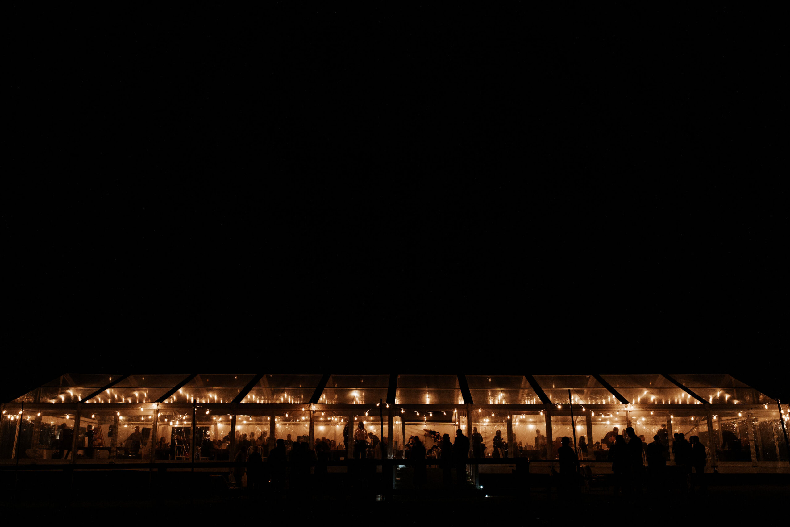 Night-time marquee event with fairy lights and elegant table settings